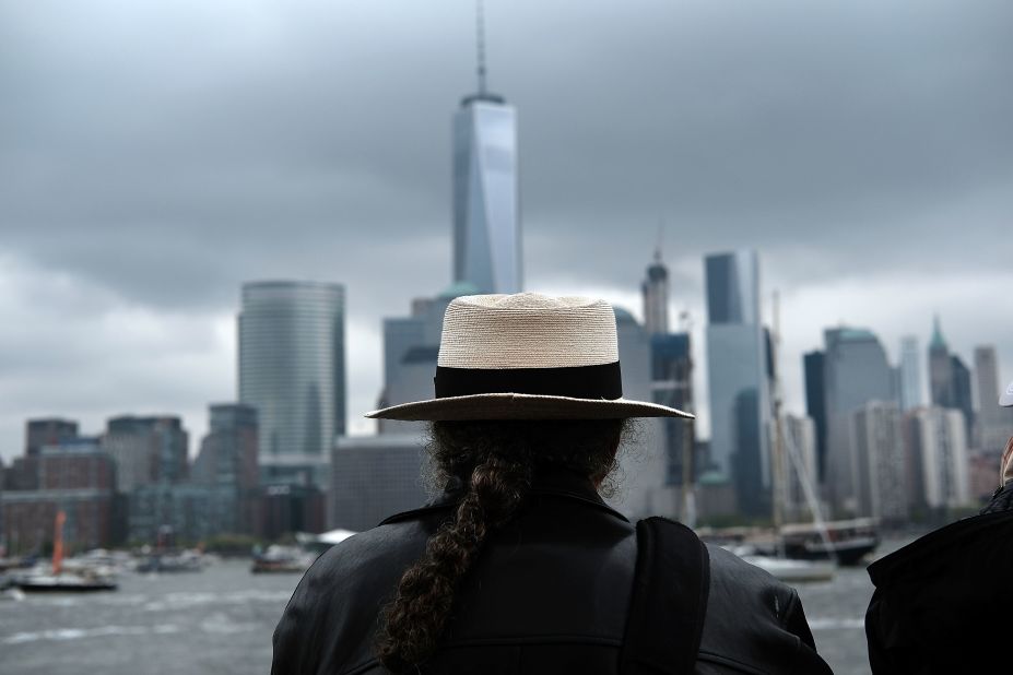 A man watches boats in New York Harbor from a vantage point in New Jersey as America's Cup racing begins Saturday.