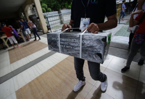An election worker carries official ballots as they are distributed to polling centers in the suburban Quezon City, north of Manila on May 8, 2016. 
