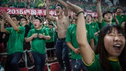 BEIJING, CHINA - JUNE 28: (CHINA OUT) Ultra supporters and fans of the Beijing Guoan FC celebrate together after a goal against Chongcing Lifan FC during their Chinese Super League match on June 28, 2015 in Beijing, China. There are growing legions of ardent supporters and fans of China's football clubs. The government is also trying to foster a football culture in the country by mandating football programs in 20,000 Chinese schools in a recent plan devised by President Xi Jinping to make China a football power. (Photo by Kevin Frayer/Getty Images)