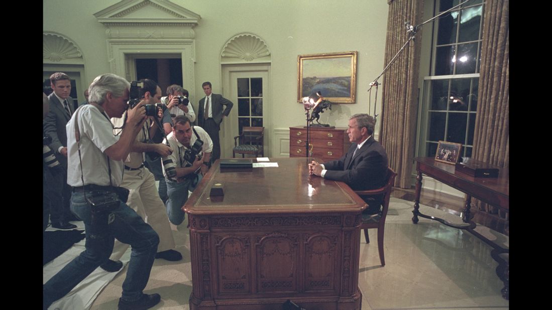 Bush pauses for members of the press before addressing the nation from the Oval Office.
