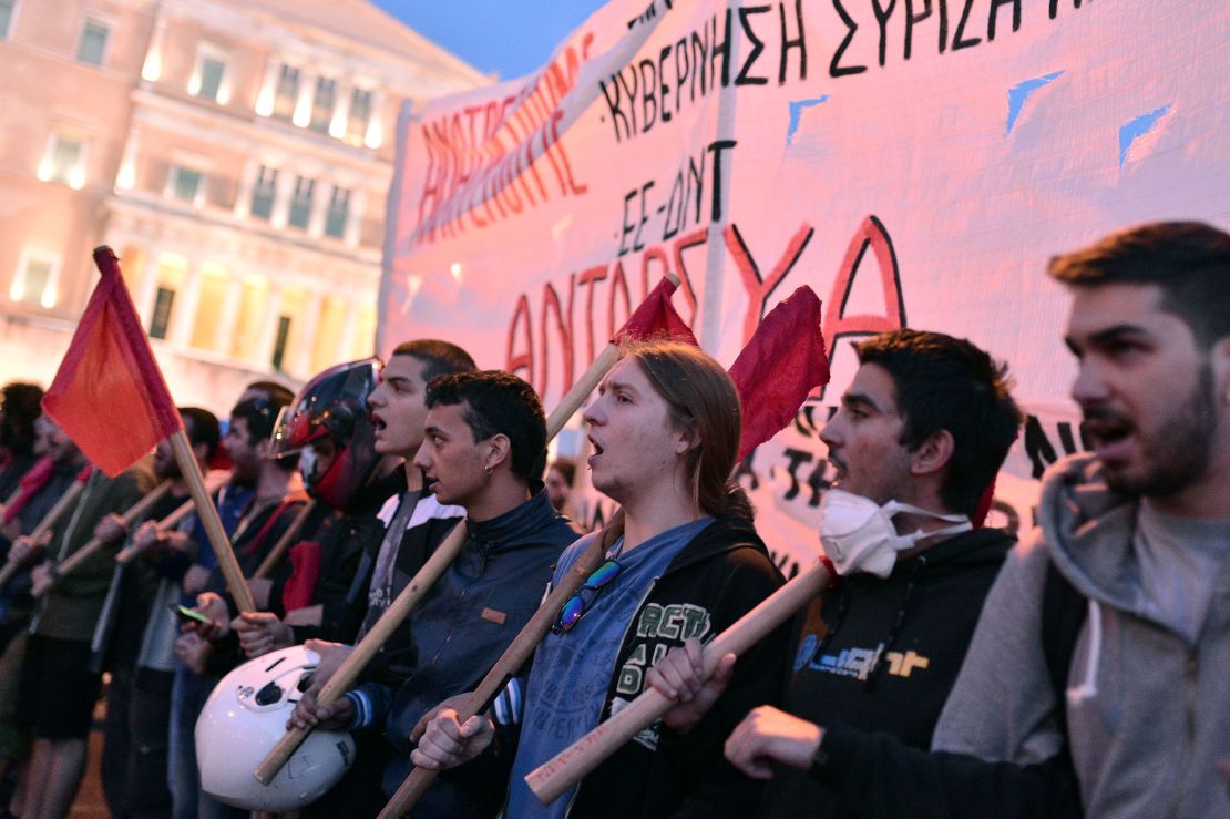 Young people shout slogans in front of the Greek parliament building in Athens on May 8, 2016. 