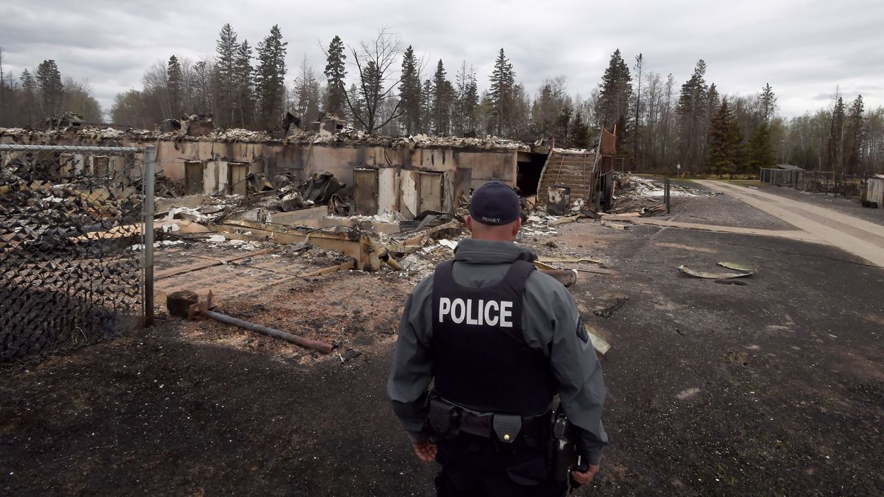 A police officer looks over a destroyed building in the Abasands neighborhood of Fort McMurray on Monday, May 9.