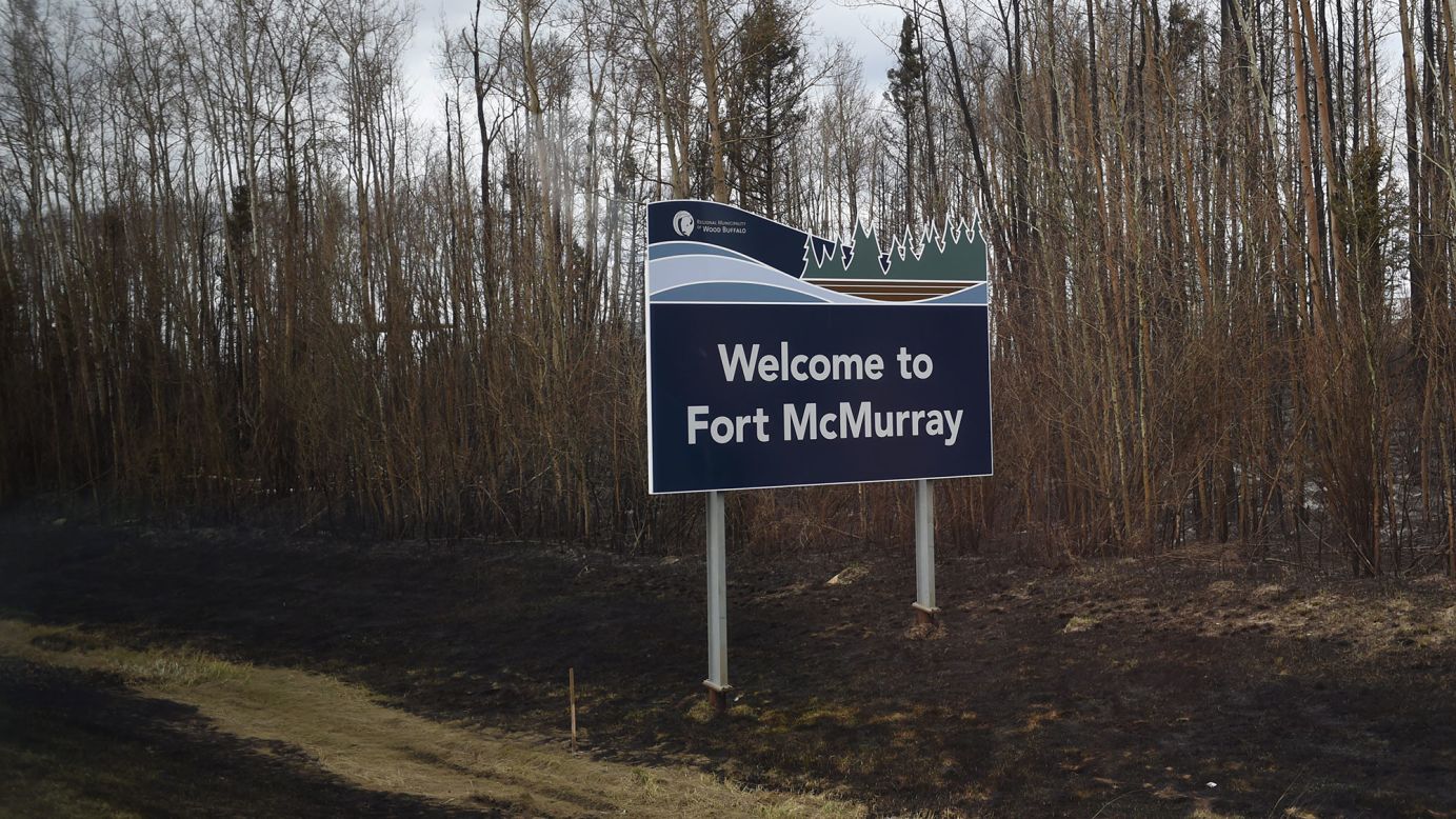 Burned ground surrounds a sign welcoming visitors to Fort McMurray on May 9. The wildfire began Sunday, May 1, and had torched nearly 617,800 acres as of May 10, according to Alberta's Wildfire Management agency. The cause of the blaze was unclear.