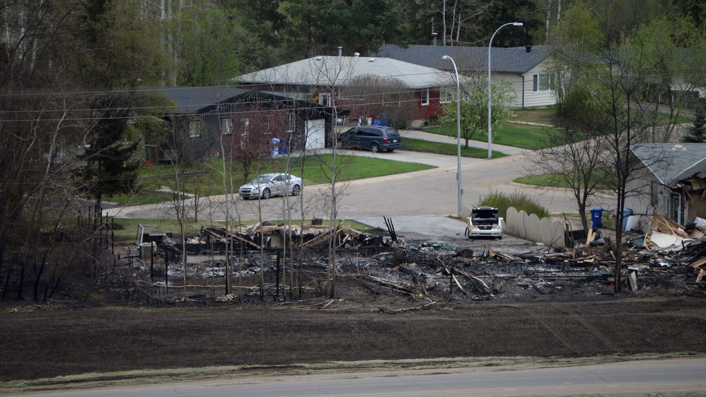 Remains of a burned-out house sit near intact homes in Fort McMurray on May 9.
