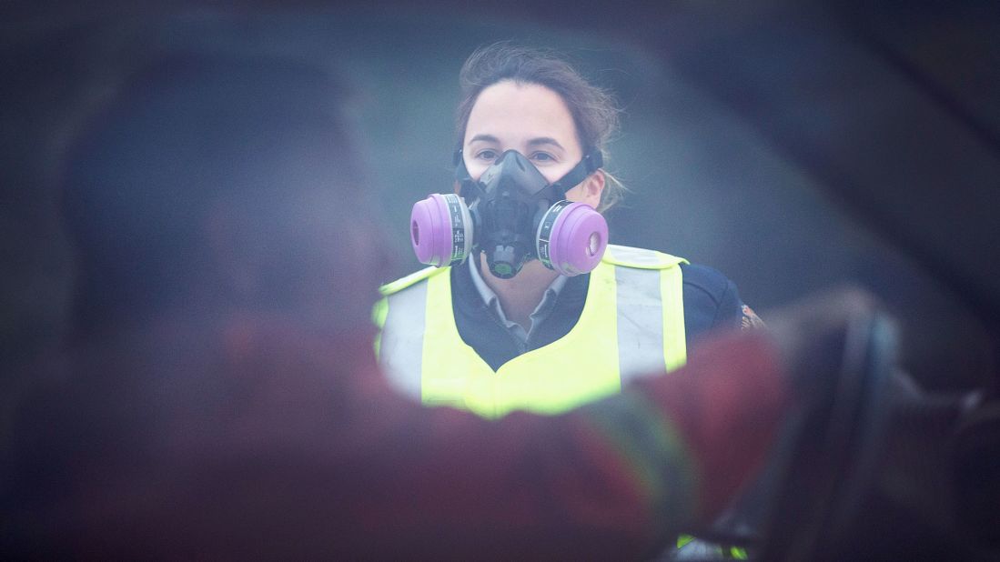 Smoke fills the air as a police officer checks vehicles at a roadblock along Highway 63 leading into Fort McMurray on Sunday, May 8.