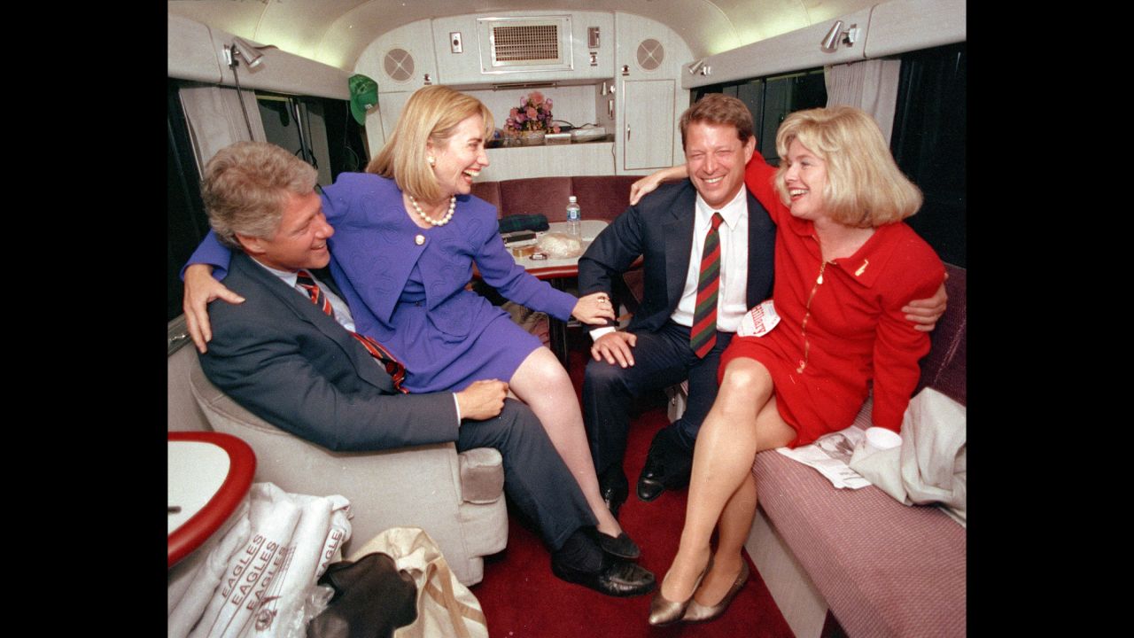 During the 1992 presidential campaign, Clinton jokes with her husband's running mate, Al Gore, and Gore's wife, Tipper, aboard a campaign bus.