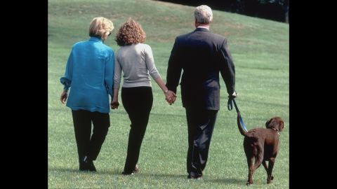 The first family walks with their dog, Buddy, as they leave the White House for a vacation in August 1998.