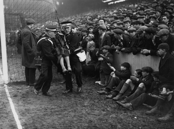 An injured spectator is removed from the crowd during a sixth-round FA Cup clash between West Ham United and Birmingham City at Upton Park in March 1933. 