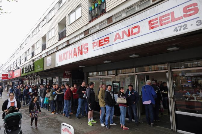 Hammers supporters queue outside a cafe serving traditional East End fare: Pie and eels. 