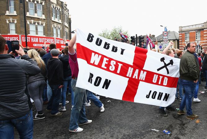 West Ham fans display a flag honoring three of the club's greatest names: former captain Bobby Moore and ex-managers Ron Greenwood and John Lyall.