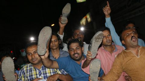 Bangladeshis show shoes as they celebrate in Dhaka.