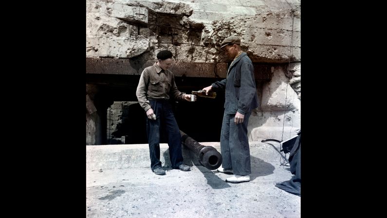 Two men share a drink at Omaha Beach in 1947. V-E Day was announced 71 years ago this week, ending the European phase of World War II.