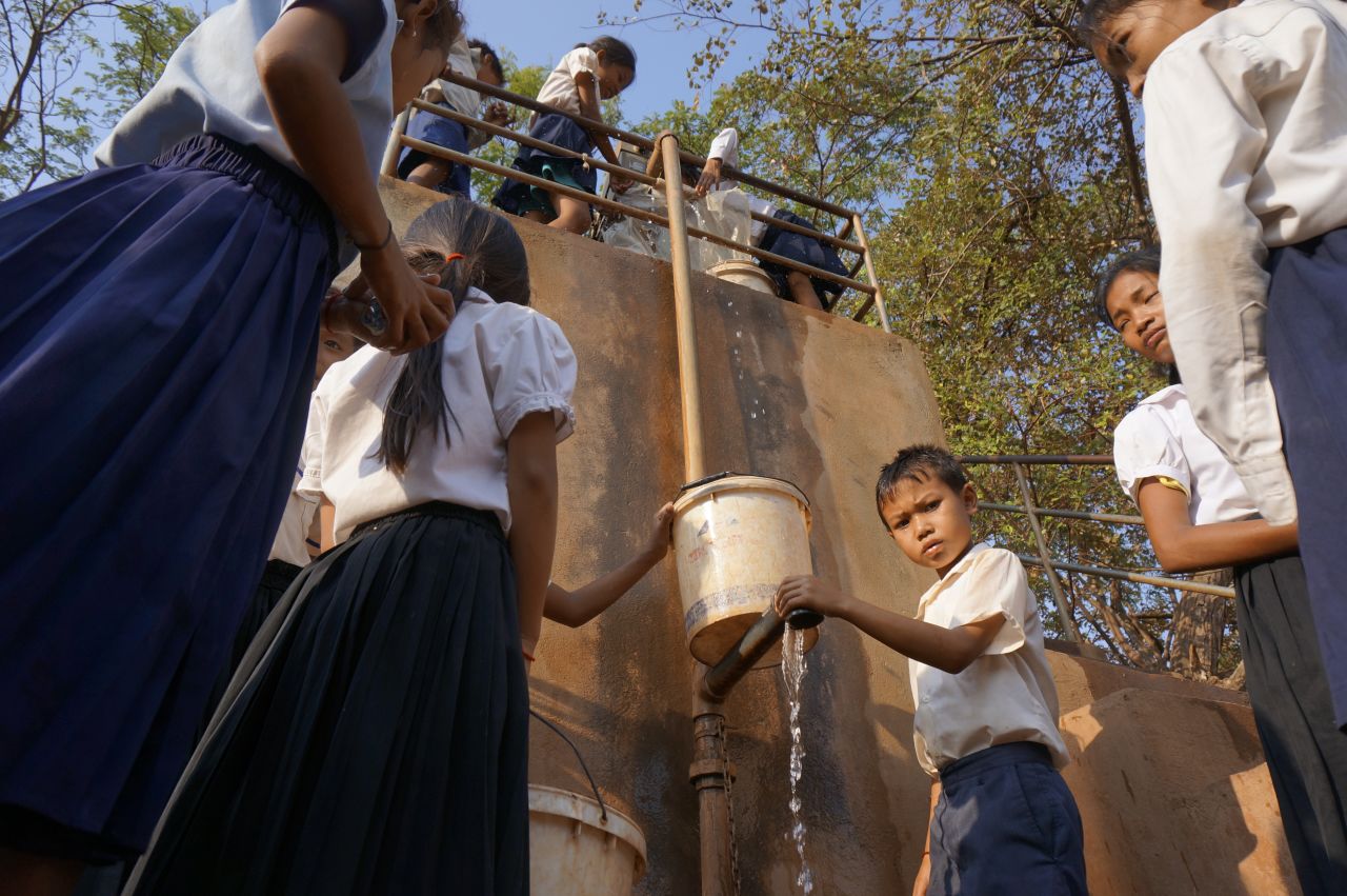 Children pump water in Tbong Khmum, Cambodia. The well is one of the few working wells left and the water has to be carefully rationed.