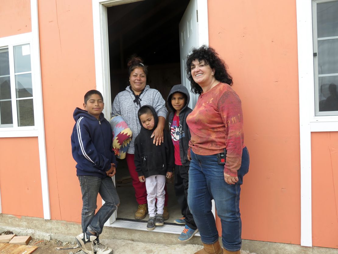 Claussen stands outside a Project Mercy home with the Cervantes family
