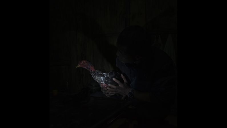 A man in the village heals a chicken. "I've always been captivated by a sense of nostalgia related to the past of human history, where daily life was linked to ancient rituals and traditions," Palazzi said.