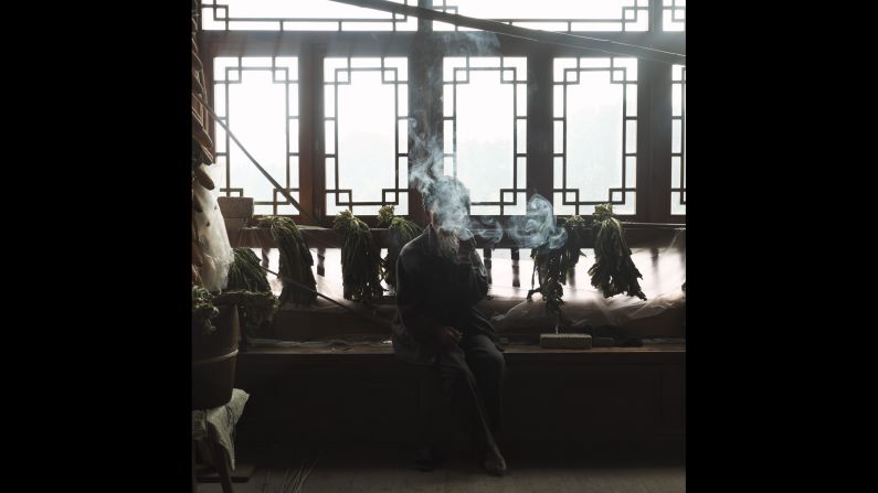 Yu Zhiguo, 84, sits inside his wooden house in the village. Both of his sons left to find better jobs in the city.