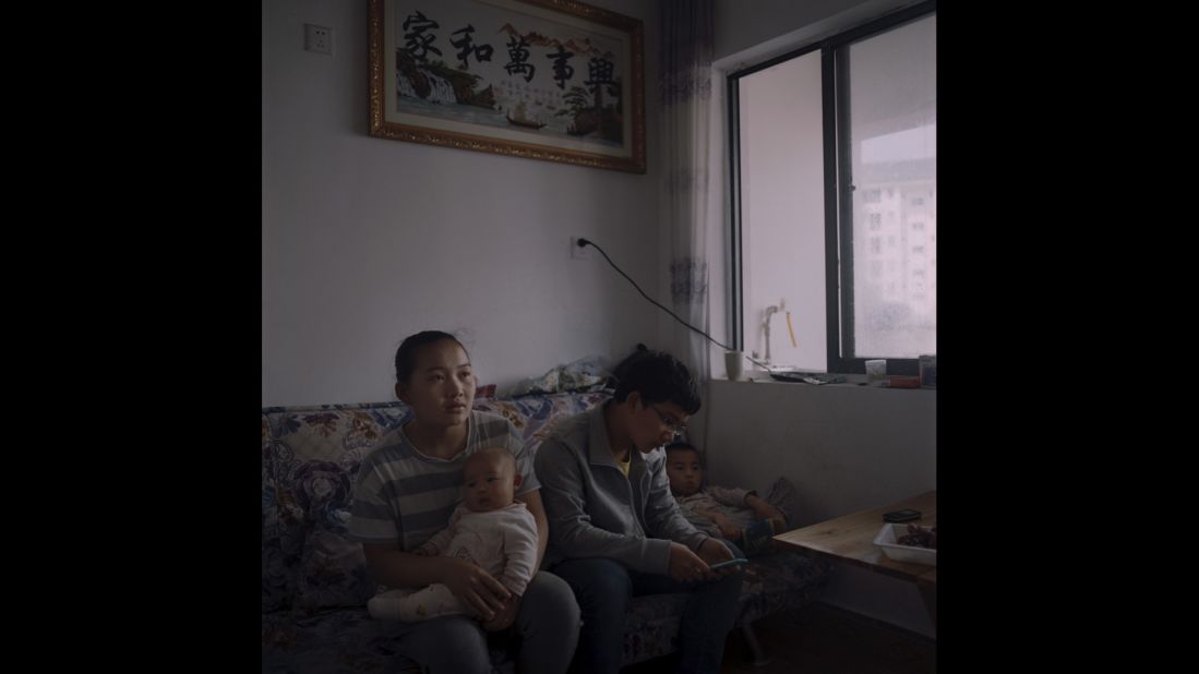 A relocated family watches television in Danzai, China.