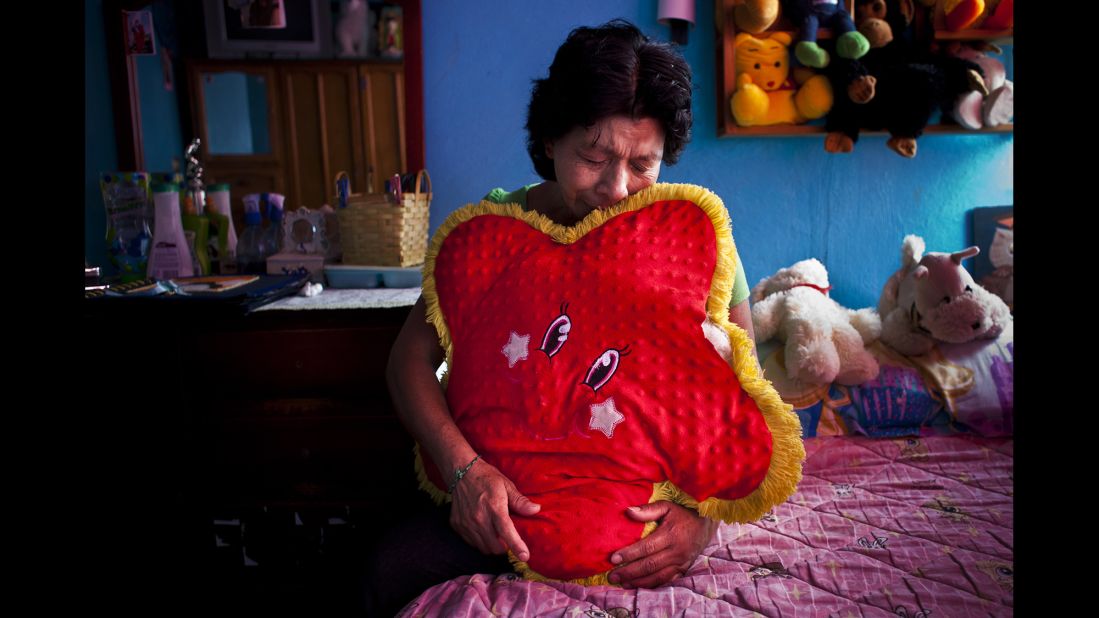 A woman in Mexico City cries in her daughter's bedroom. Her daughter Amairay was an 18-year-old student who disappeared in 2012.