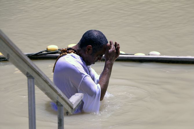 A pilgrim immerses himself in the waters of the Jordan River. UNESCO recognizes the official site of Jesus' baptism as the east bank of the river in Jordan, called Al-Maghtas ("baptism").