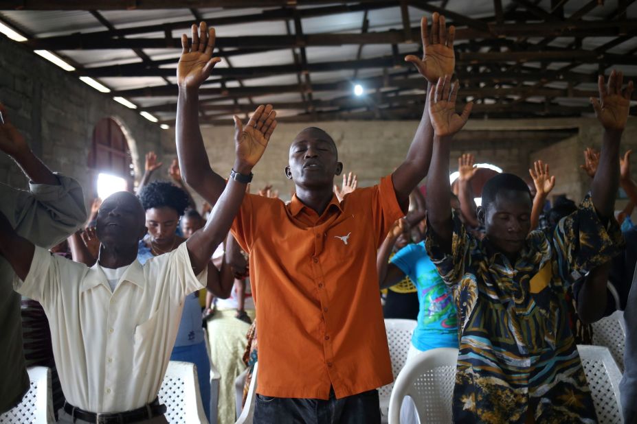 Church members of the Bethlehem World Outreach Ministry International in Liberia pray at a Sunday service during the Ebola epidemic.