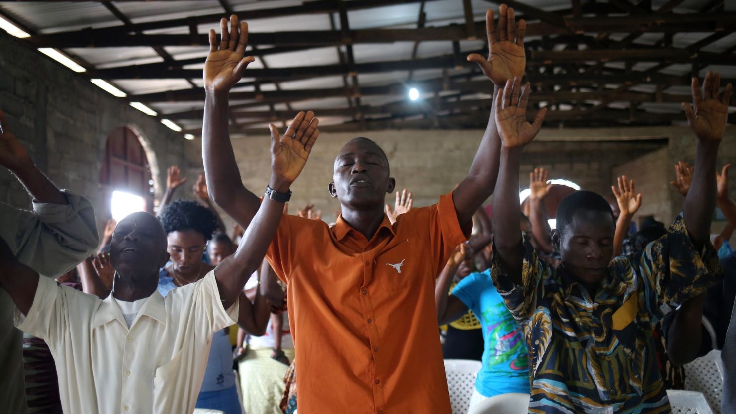 Church members pray during a Sunday service at a church in Dolo Town, Liberia, on August 24, 2014.