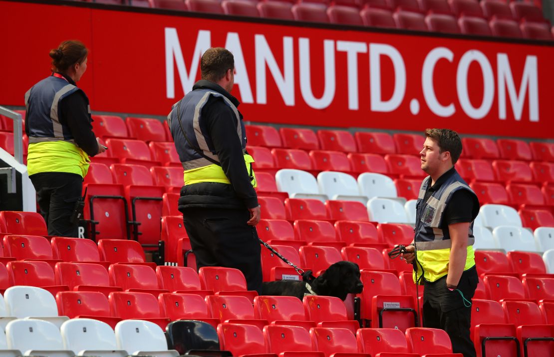 A sniffer dog patrols the Old Trafford stands.