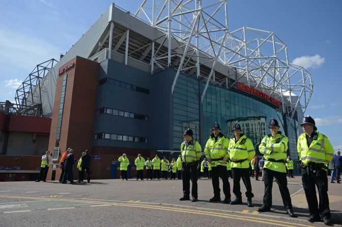 Police officers stand on duty outside Old Trafford stadium after the English Premier League football match between Manchester United and Bournemouth was abandoned Sunday.