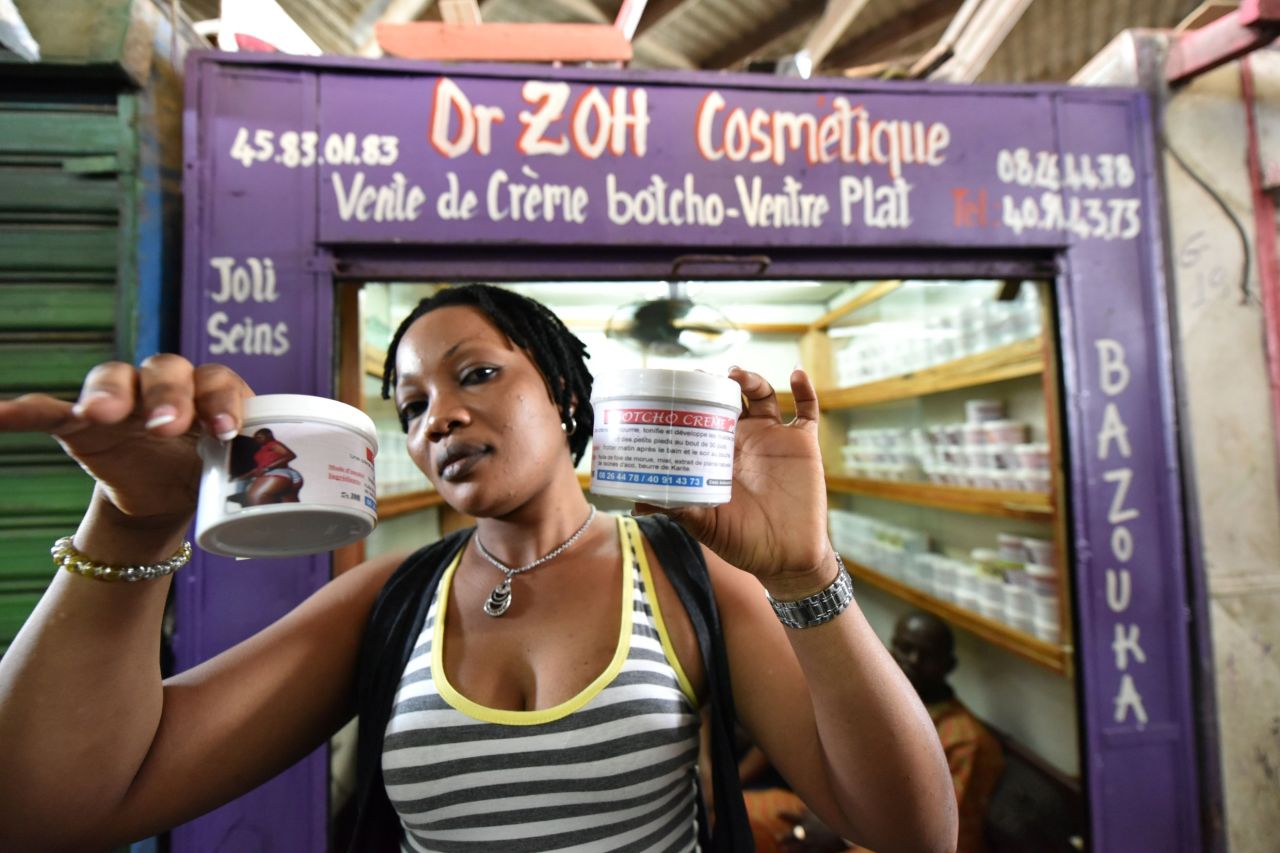 A shopkeeper in a market in Abidjan shows pots of cream thought to help enhance bottoms. The cream's label says it's made of cod-liver oil, honey or shea butter. 