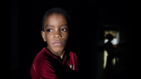 Hussein, 7, poses for a portrait. He's a brother of Essa in the first photo.