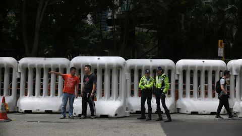 Police officers stand in front of large barricades erected along a road in Hong Kong on May 16, 2016.