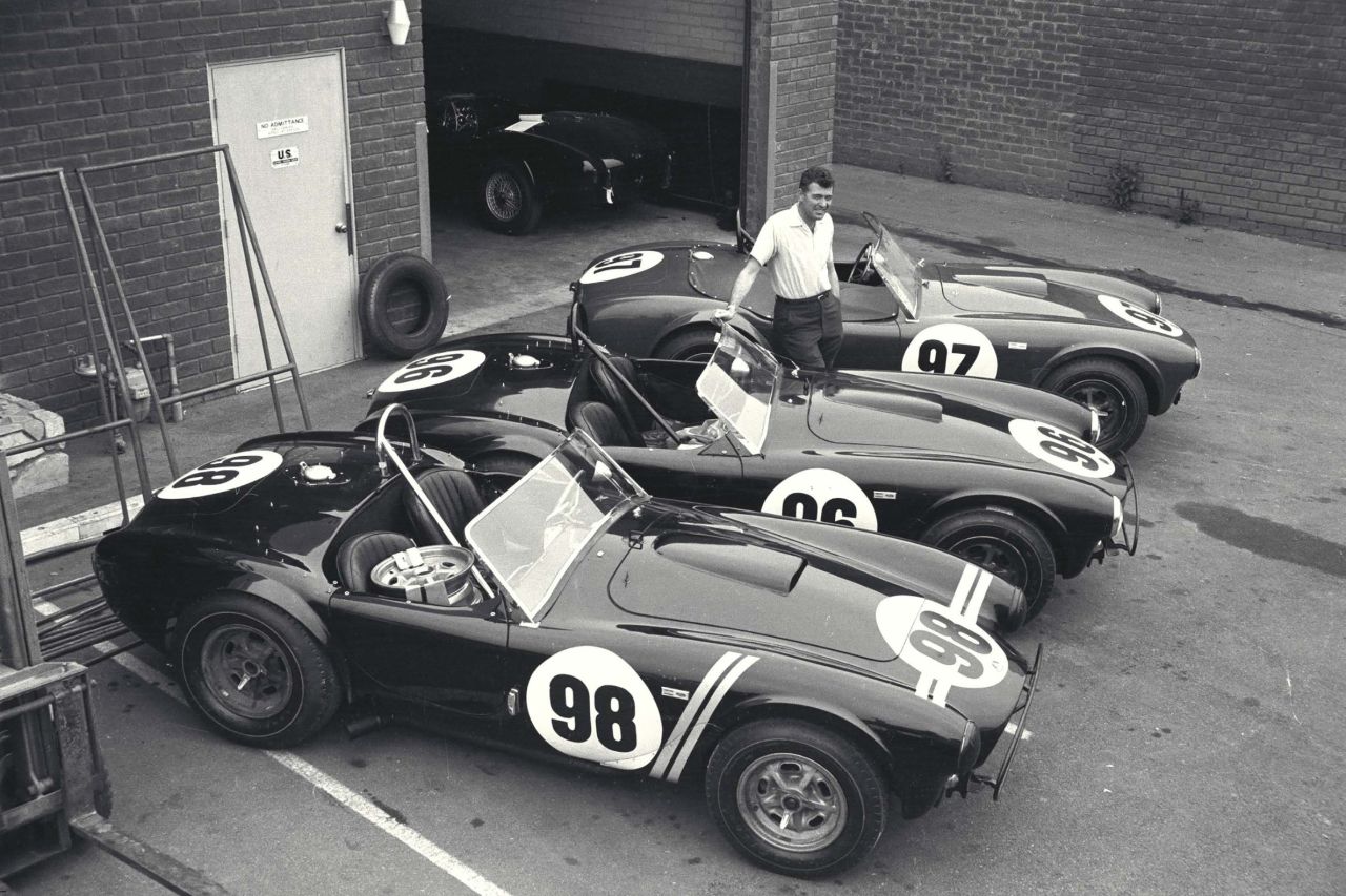 Car designer Carroll Shelby with the three Shelby Cobra roadsters that would win the 1963 USRRC Manufacturer's Championship. The brand worked with David Yurman to produce a black rubber-coated steel chronograph with the Shelby double racing stripe on the dial.
