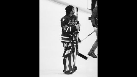 Jim Craig, goalie for the USA Olympic hockey team, holds the American flag on the ice rink after defeating Finland at the 1980 Olympics.
