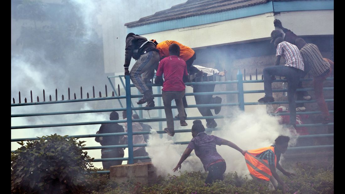 Opposition supporters climb over a fence into the University of Nairobi campus as they flee from clouds of tear gas fired by riot police. "The protests started a couple weeks ago, and have been taking place every Monday outside the offices of the electoral commission." Curtis said. 