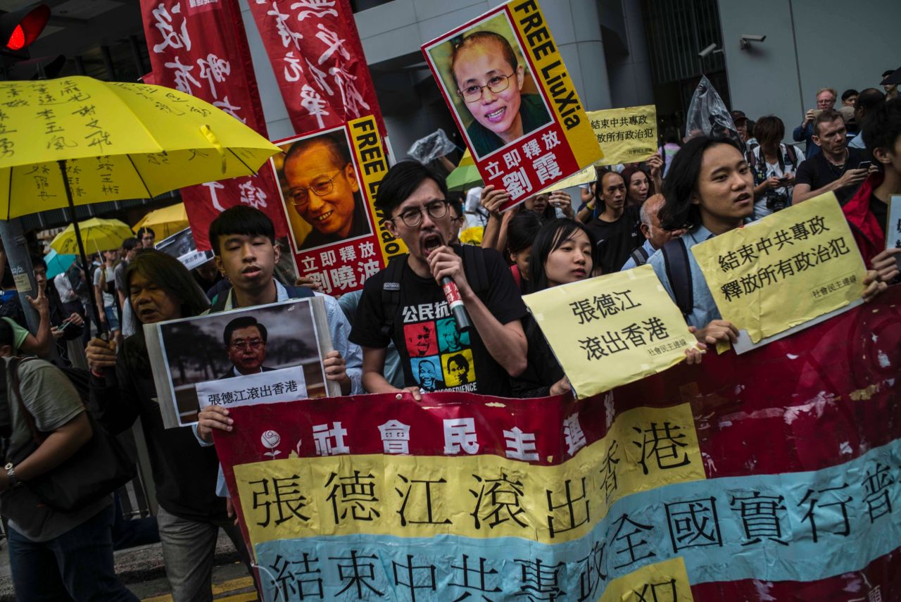 Hong Kong pro-democracy activists hold pictures of Zhang, as well as images of detained Chinese Nobel Peace laureate Liu Xiaobo and his wife Liu Xia, as they march to Government House on May 17.