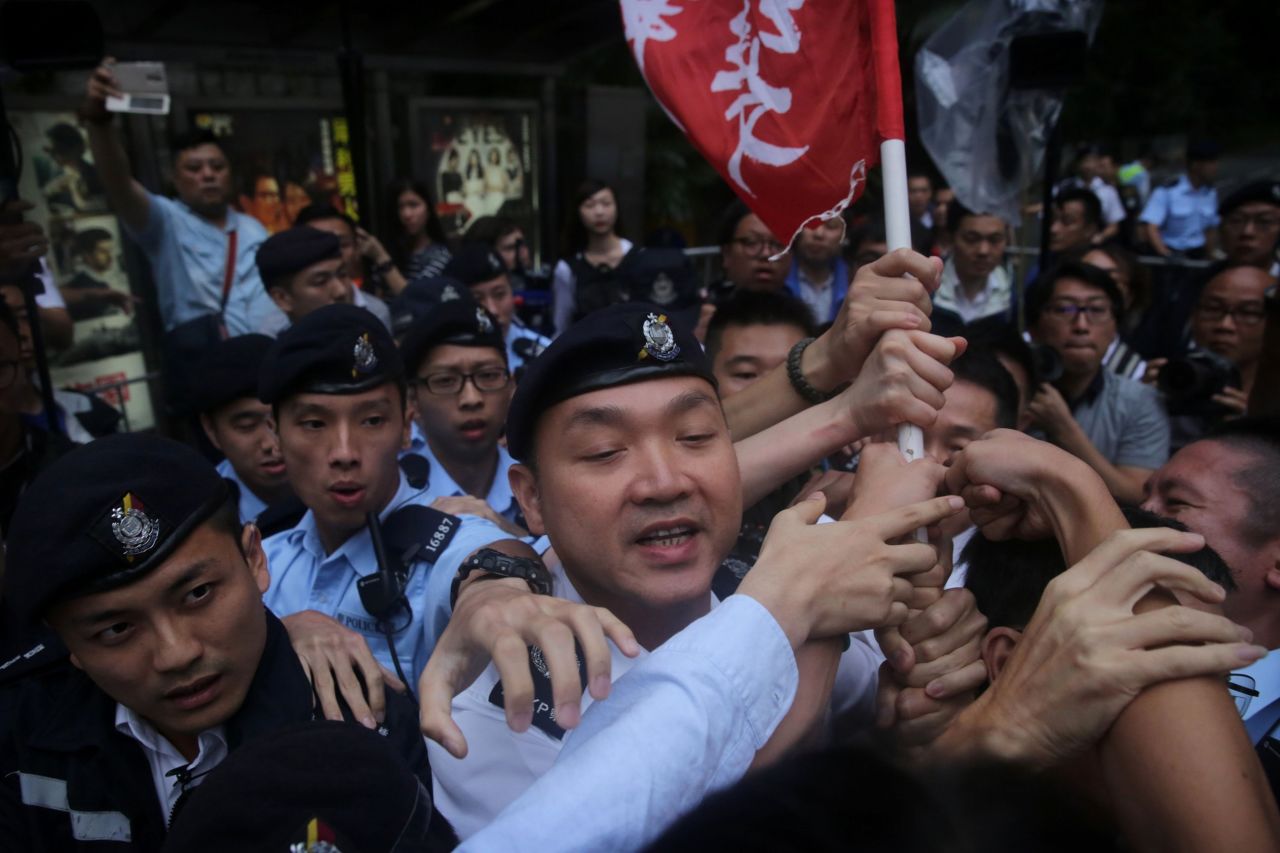 Hong Kong police try to confiscate a flag during a League of Social Democrats protest outside the Central Government Headquarters in Hong Kong, on the first day of Zhang Dejiang's visit, Tuesday, May 17.