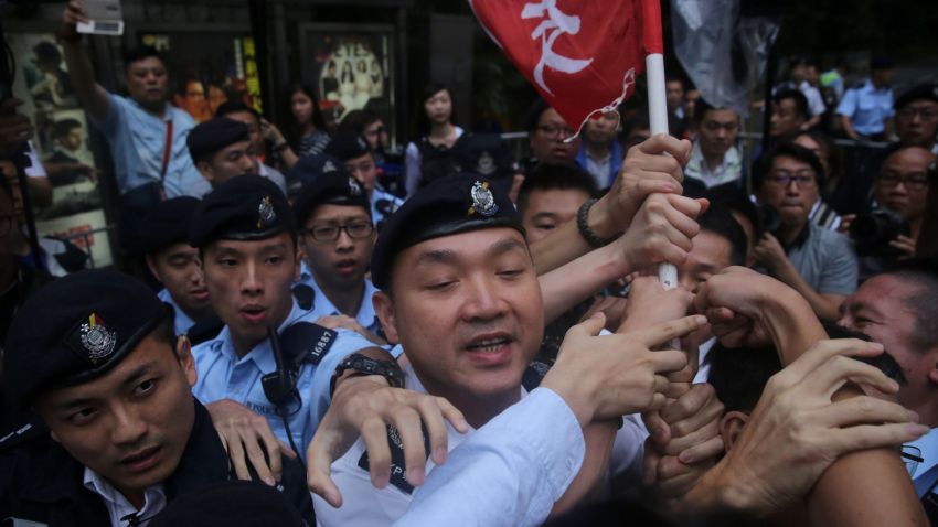 Police try to confiscate a flag during a League of Social Democrats protest outside the Central Government Headquarters in Hong Kong on May 17, 2016, in a demonstration coinciding with the visit of Zhang Dejiang - who chairs China's communist-controlled legislature - to the territory. One of China's most powerful officials said he would listen to political demands from Hongkongers in a conciliatory start to a visit May 17 that has stirred anger in a city resentful of Beijing's tightening grip. / AFP / ISAAC LAWRENCE        (Photo credit should read ISAAC LAWRENCE/AFP/Getty Images)