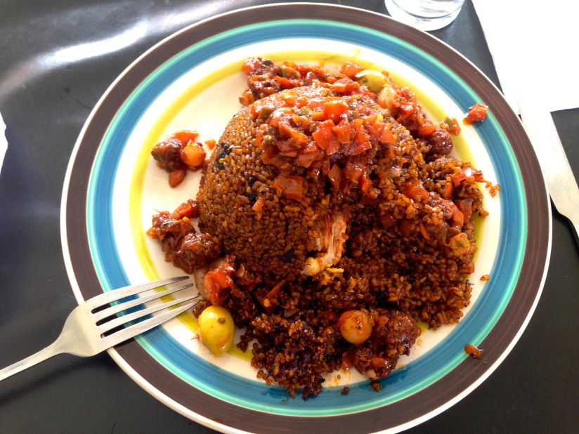 Senegalese specialty Thieboudienne is made from fish, rice and vegetables simmered in tomato paste and stock. This hearty dish, Thiebou Yapp Guinar, is made with chicken, olives, and crunchy balls of fried rice. 