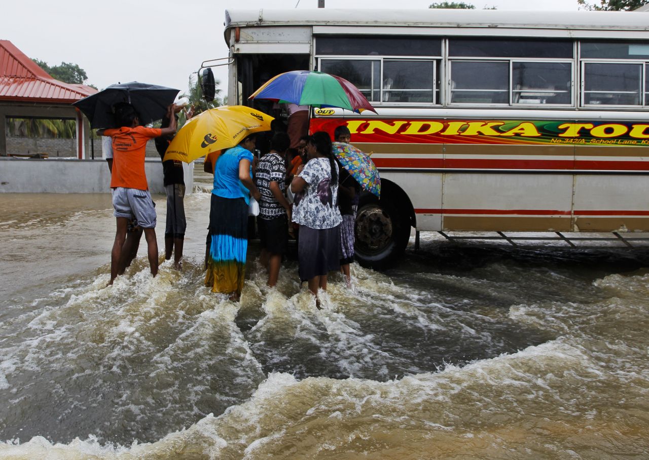 Flood victims flock around a bus to receive food parcels on a inundated road in Colombo on May 17. 
