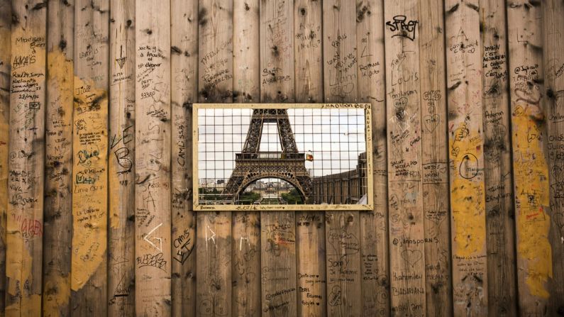 The Eiffel Tower is seen through a grille in wooden panels surrounding a construction site. The iconic tourist attraction finished in 14th place in TripAdvisor's 2016 list of the world's <a href="index.php?page=&url=https%3A%2F%2Fwww.cnn.com%2F2016%2F05%2F17%2Ftravel%2Ftripadvisor-top-world-landmarks%2Findex.html" target="_blank">most-beloved landmarks.</a>