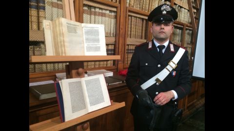 An Italian security officer in Rome stands with a rare copy of a letter written by Christopher Columbus in 1493 to King Ferdinand and Queen Isabella of Spain. The letter apparently was stolen from a Florence museum more than 65 years ago.