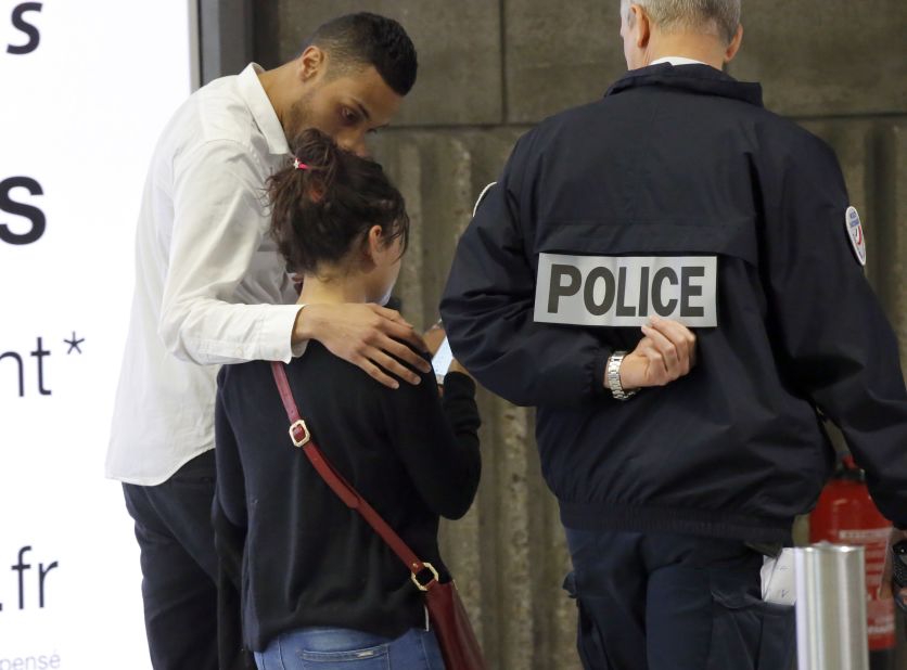 A relative is escorted at Paris' Charles de Gaulle Airport. 