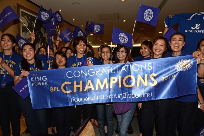 Leicester City's jubilant players and staff are greeted by a banner of congratulations as they arrive in Thailand.