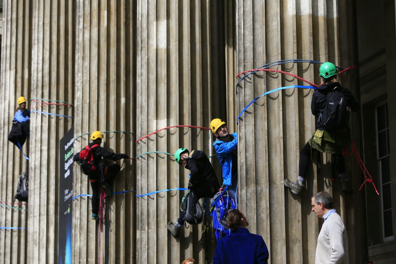 The climbers unfurl seven huge banners down the front columns of the British Museum, which carry the names of cities and regions struck by flooding and climate change disasters.