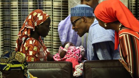 Nigerian President Muhammadu Buhari hold Amina Ali's baby.