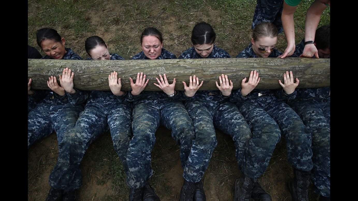 Plebes from the U.S. Naval Academy perform situps with a 12-foot log on top of them during the annual Sea Trials training exercise on Tuesday, May 17.