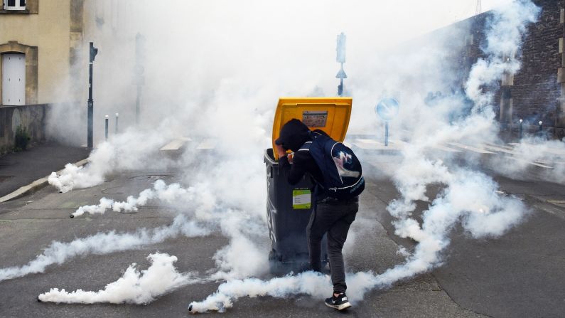 A man in Rennes, France, shields himself from tear gas canisters during a demonstration against the government's planned labor law reforms on Tuesday, May 17.