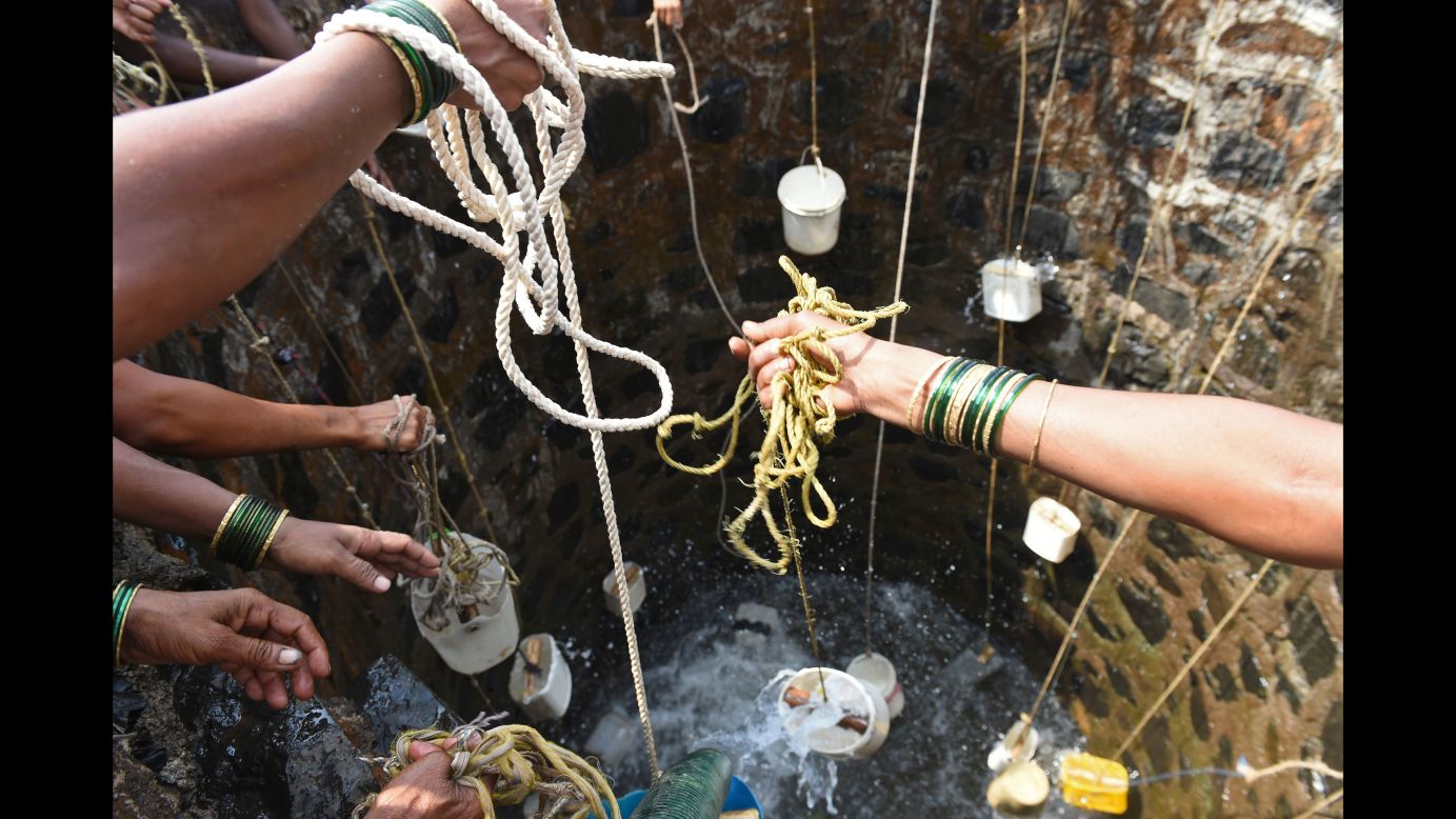Villagers in Shahapur throw containers into a well on May 13.