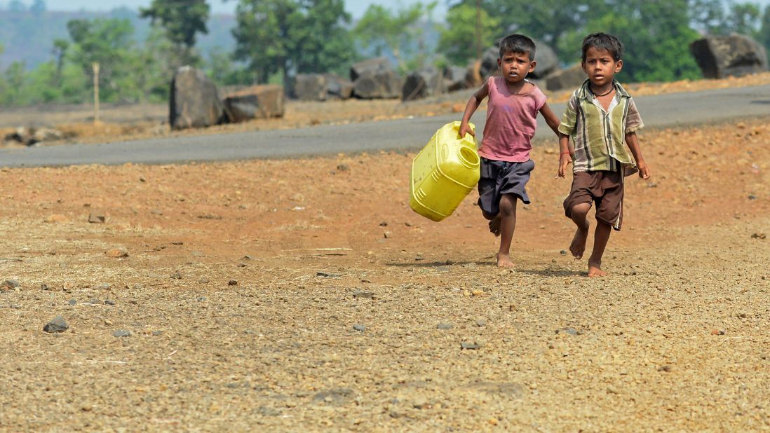 Children run with containers toward a well in Shahapur, India, on May 13 2016. 