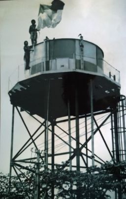 Ret. Sergeant Major Nguyen Van Can (below) and his comrade raise the liberation flag on top of the water tower at Tan Son Nhat airport.