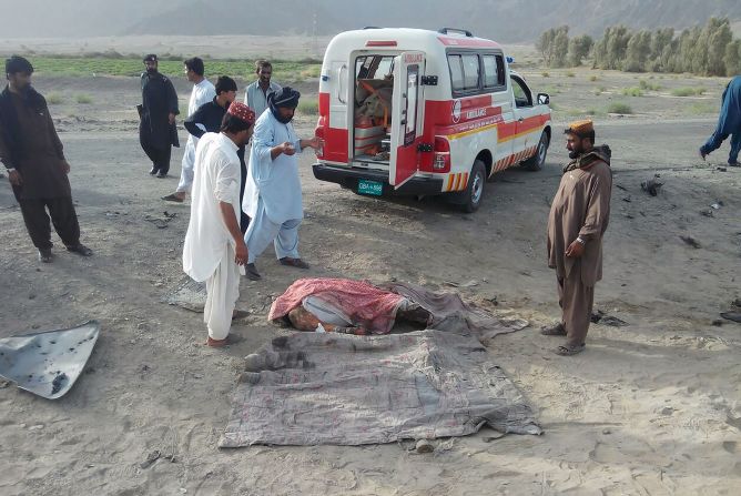 An unidentified body lies covered on the ground before being loaded into a waiting ambulance May 21.